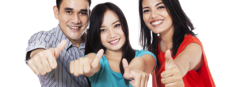 Group of happy friends giving thumbs up - at campus